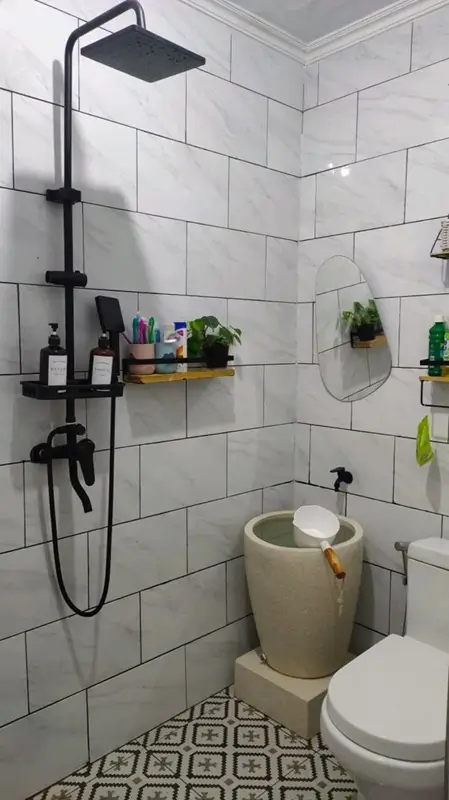 Kamar mandi dengan shower hitam dan lantai motif